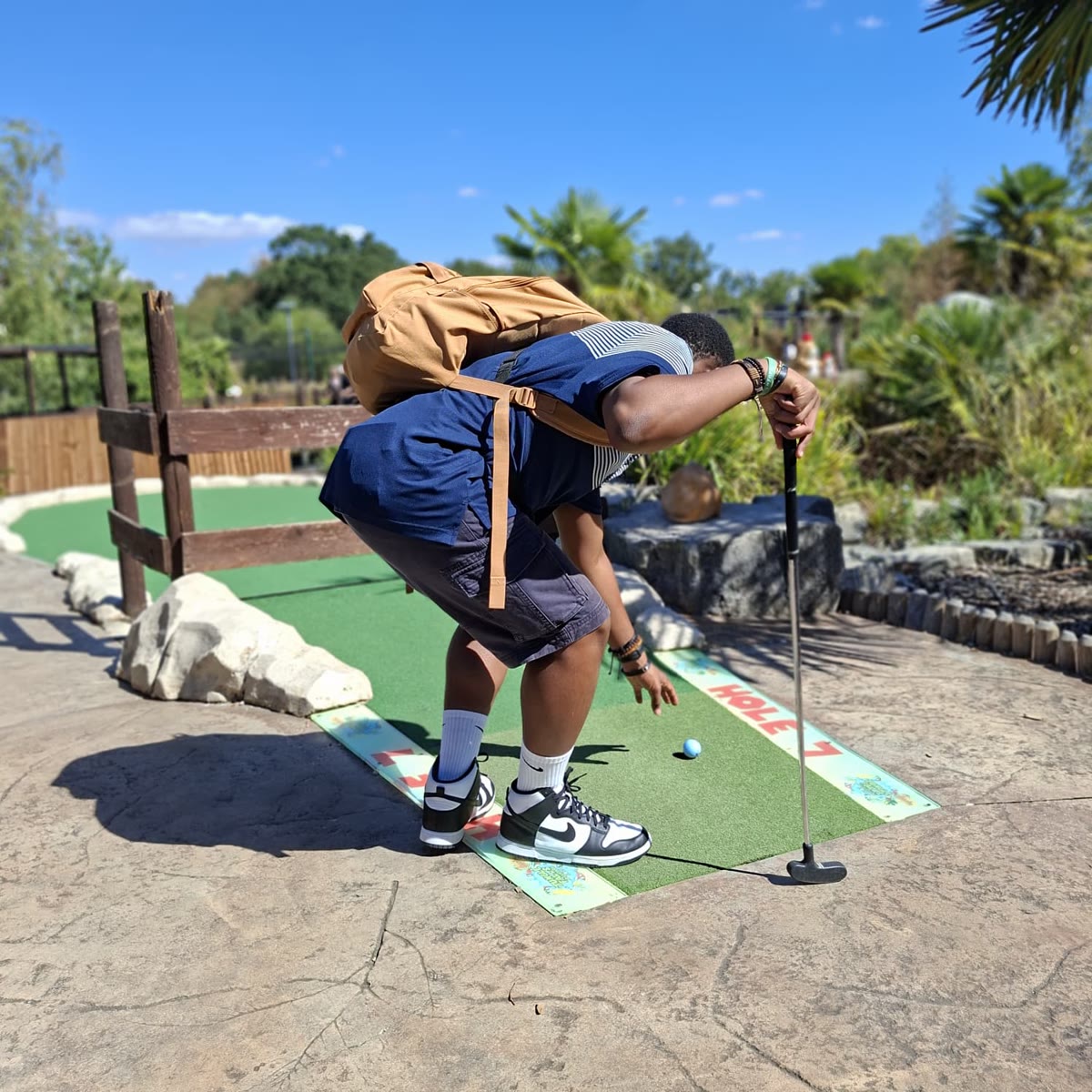 Henry crouching down to line up his putt on hole 7